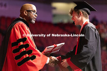 A student shakes hands with Chancellor Rodney D. Bennett before receiving his diploma at the afterno