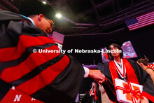 Fatima Al-Jayashi accepts a grad pin from Jordan Gonzales '17, senior director of alumni engagement 