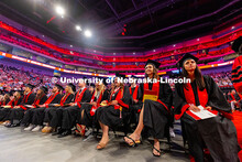 College of Journalism and Mass Communications graduates laugh as they wait to receive their diplomas