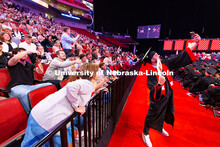 Business Administration graduate Jarrett Michie holds his phone up to get a selfie with more than a 