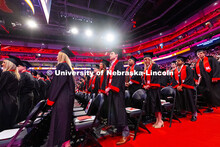 Business Administration graduates rise toward the end of the morning undergraduate commencement cere
