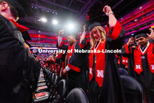 Business Administration graduates Corey Nguyen (l) and Emily Nau (r) move their tassels to the left 
