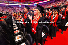 Business Administration graduate Emily Nau claps at the end of the University of Nebraska–Lincoln'