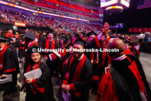 Chancellor Rodney D. Bennett high-fives a student as graduates exit Pinnacle Bank Arena after the Un