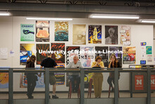 Visitors sit in front of a wall of projects from Professor, Jesse Fleming’s, Visual Expression Stu