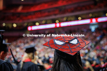 A graduating senior wears a decorated Spiderman-themed grad cap during the May 2025 Commencement Und