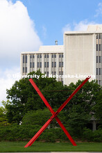 Old Glory sculpture's red beams pop against the green foliage east of Hamilton Hall. Spring on City 