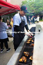 Franklin Yankton smiles as he flips chicken and ribs on a grill outside of the East Campus Dining Ce