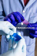 Stephen Morin, Associate Professor of Chemistry, and doctoral student Brennan Watts hold two colorfu