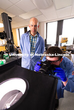 Doctoral student Brennan Watts points a camera at a small light box he and Stephen Morin, Associate 