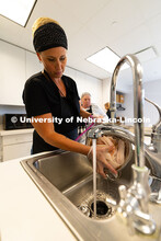 Dusty Stevens drains water from a thawed package of whitefish fillets, which were then rubbed with b