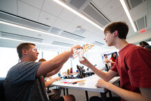 Ryne Callahan and Joe Lake work together to create a bridge made from 20 straws and tape during engi