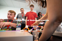 Joe Lake (red shirt) and Ryne Callahan watch as Rachel Rose, coordinator of engineering outreach, pl