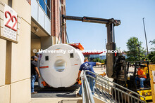 Workers use a crane to lift the new MRI scanner into Memorial Stadium. The new scanner will be used 