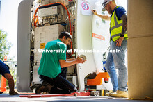 Workers from Cassling install wheels on the tools that will help them pull the new MRI scanner into 