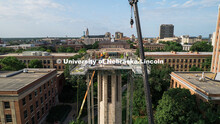 Construction workers stand on scaffolding near the top of Mueller Tower. The tower is undergoing a r