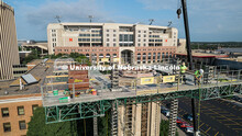 Construction workers stand on scaffolding near the top of Mueller Tower. The tower is undergoing a r