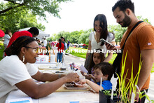 Bellodgia Roberson, a graduate student studying agriculture and horticulture, helps three-year-old J