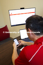 Parker Reed glances at his cell phone. Reed is an academic navigator for the College of Business, an