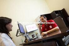 Parker Reed speaks with Mireu Ryu, a senior studying computer science, in his office in Hawks Hall. 