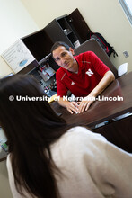 Parker Reed speaks with Mireu Ryu, a senior studying computer science, in his office in Hawks Hall. 