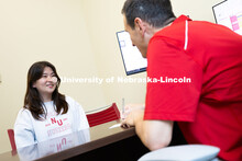 Parker Reed speaks with Mireu Ryu, a senior studying computer science, in his office in Hawks Hall. 