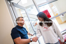 Dave Nebel shakes hands with Mireu Ryu, a senior studying computer science, at the entrance to the b