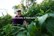 Bill Sorensen grins over the tops of his hot pepper plants in the plot he rents in the East Campus C