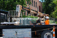 Ostin Gustafson guides Charles Tucker, truck lift operator to place a pallet of stone on a flatbed. 