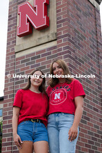 Sisters Madison and Lauren Haring pose next to a Husker "N" on the entrance gates by the Nebraska Un