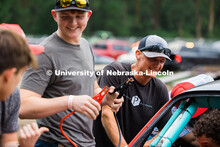 UNL Figure 8 Racing members Cayden Witzel (left) and Bricen Wilkie (right) work on the race car betw