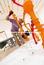 Delan Lonowski, an on-call exhibition technician for the Sheldon Museum of Art, fits one of the smal