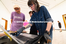 Delan Lonowski (left) and Quentin Fortney (right), on-call exhibition technicians, move part of a sc