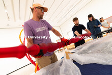 Delan Lonowski (left) and Quentin Fortney (right), on-call exhibition technicians, move part of a sc