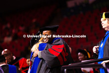 Esihle Lupindo hugs Professor Lisa Kort-Butler after being hooded. Lupindo received his doctorate in
