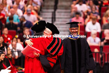 Weiman Xu hugs a professor after receiving her doctorate during the summer commencement ceremony. Su