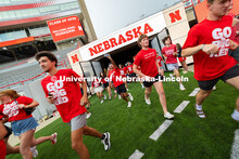Students run onto the field during the Tunnel Walk into Memorial Stadium. The Tunnel Walk is for inc