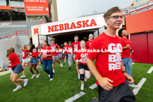 Students run onto the field during the Tunnel Walk into Memorial Stadium. The Tunnel Walk is for inc