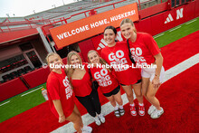 Students pose in front of a sign that says, "Welcome Home, Huskers!" during the Tunnel Walk into Mem