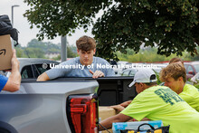 Sam Niven grabs his things from his family’s truck while Tylo Van Wyk helps (white hat). August 19