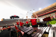 Members of the pit raise their mallets during a percussion performance within the marching band exhi
