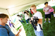Micah Caverzagie holds Diamond, a young goat from the Shepherd's Rest goat and sheep rescue. He and 