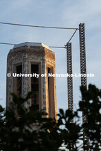 Morning sunlight touches Mueller Tower's exposed brick as scaffolding supports surround it as constr