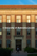 A student walks to class in front of Burnett Hall as the sun rises on city campus. September 11, 202