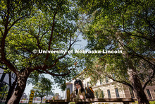 Olivia, a university student, sits on a shaded bench during a sunny afternoon outside of Architectur