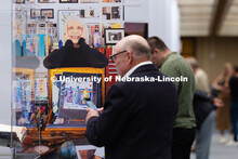 A portrait of artist Karen Blessen looks out over the heads of visitors to “The Muck, the Seeds, t