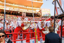 Davin Seeger, cymbalist for the Cornhusker Marching Band, crashes his cymbals and cheers during the 