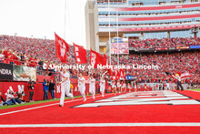 The Nebraska Spirit Squad runs along the end zone with flags that spell out Nebraska after a touchdo