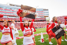 Spirit Squad member, Grace Nab, holds up a sign that says “Defense” during the Nebraska vs Akron