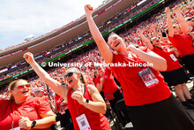 Flagbearer members in the alumni marching band scream "Go Big Red" after a touchdown. The alumni ban